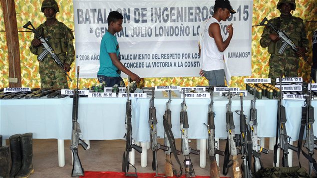 Deux membres de l'Armée de libération nationale (ELN) cèdent leur AK-47 à l'armée colombienne en décembre 2008, à Quibdo, en Colombie.
