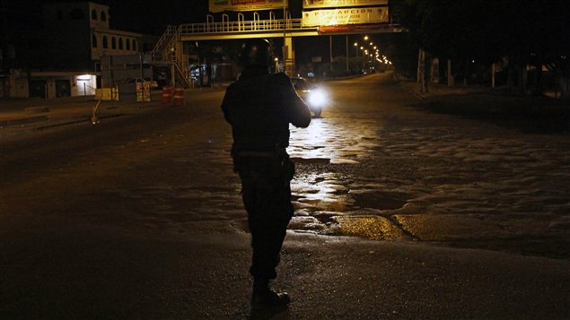Un policier mexicain pointe son arme vers un véhicule transportant un présumé trafiquant de drogues
