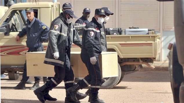 Des pompiers algériens portent un cercueil sur le complexe gazier d'In Amenas.