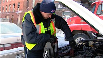 Un technicien du CAA procède au survoltage d'une voiture.