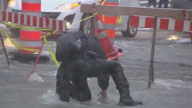Ce piéton a eu du mal à se frayer un chemin au milieu de la rue inondée.