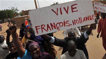 Des Maliens brandissent des pancartes remerciant le président français, à Ansongo, proche de la frontière avec le Niger.