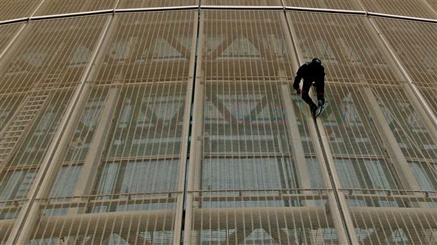 Le Français Alain Robert lors de son escalade à mains nues d'un hôtel de Doha en avril 2012