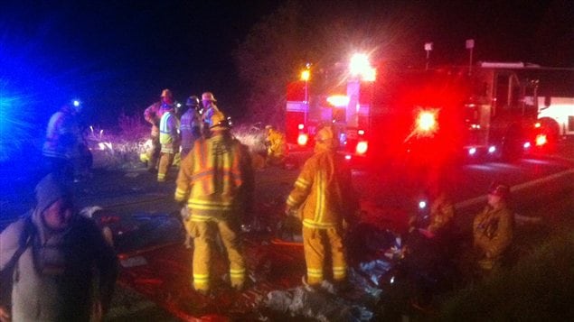 Des secouristes aident des blessés de l'accident d'autobus, dimanche soir, sur une autoroute proche de Forest Falls, en Californie.