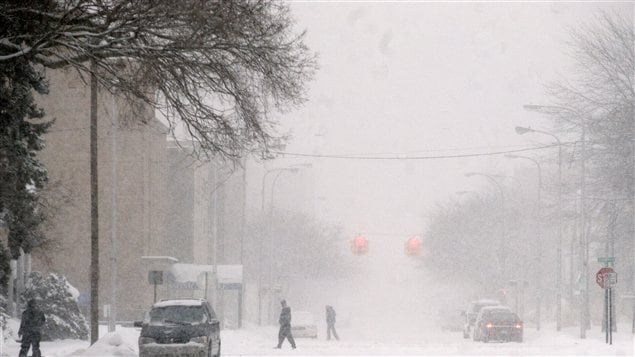 Des gens traversent la rue à Muskegon au Michigan le 7 février. Il neige depuis jeudi dans cette région.