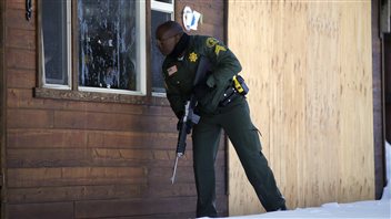 Un policier à la recherche de Christopher Dorner regarde à l'intérieur d'une maison de Big Bear Lake, en Californie.