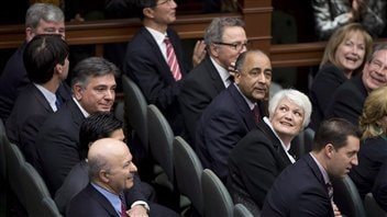 Les nouveaux ministres de l'Ontario regardent vers la mezzanine de l'Assemblée législative durant leur cérémonie d'assermentation, le 11 février 2013.