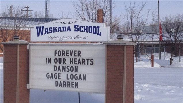 Le drapeau est en berne à l'école de Waskada, le 11 février 2013, et une inscription rend hommage aux disparus dans un accident d'avion survenu la veille, près de cette communauté du sud-ouest manitobain.