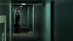 Un agent de la Police de Toronto surveille la porte de l'appartement où un jeune de 15 ans a été abattu tard le 11 février 2013.