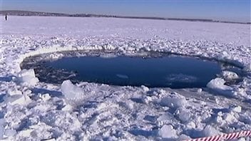 Le trou percé dans la glace d'un lac de l'Oural par un des débris de la météorite. L'objet a percé près d'une vingtaine de centimètres de glace.