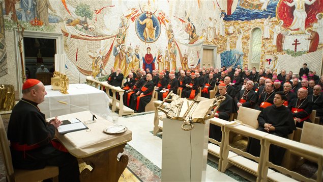 Un cardinal s'adresse à ses confrères au Vatican, le 23 février, tandis que le pape (dans la pièce à gauche) prie.
