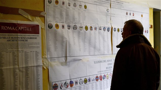 Un Italien regarde des informations sur les élections dans un bureau de vote, le 24 février.