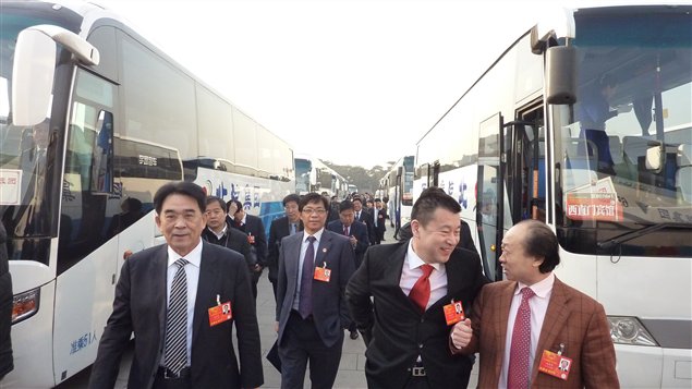 Les représentants du gouvernement chinois arrivent en bus au palais de l'Assemblée du peuple.