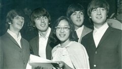 Jeune montréalaise entourée des quatre membres des Beatles au Forum de Montréal le mardi 8 septembre 1964.