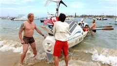 Le Canadien Adam Kreek (g) et les Americains Pat Flemming et Jordan Hanssen le 23 janvier 2012 sur la plage de Ngore près de Dakar.