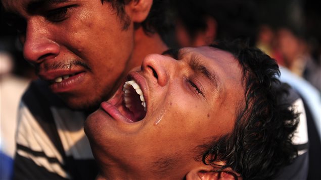 Ce jeune homme vient de reconnaître un membre de sa famille, mort dans l'effondrement de l'immeuble près de Dacca.