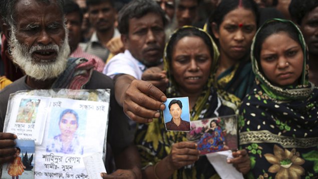 People hold out pictures of missing relatives in Savar, near Dhaka, Bangladesh. Rescue workers in Bangladesh have now given up hope of finding any more survivors in the remains of the factory building that collapsed on April 24. 