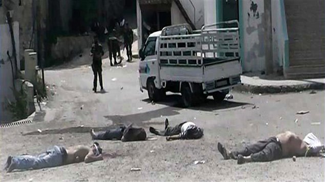  صورة التقطها مواطن صحفي نشرت أمس ومثبتة صحتها بالاستناد إلى مضمونها وإلى تقارير لوكالة "أسوشيتد برس" تظهر جثثاً في بلدة البيضا وفي العمق جنوداً سوريين موالين للرئيس بشار الأسد 
