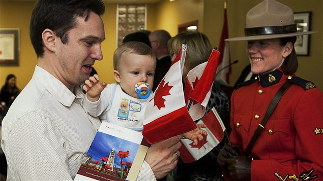 La constable Meredith Darrah regarde Michael Kopec, originaire de la Slovaquie, qui prend part avec son fils Max à une cérémonie de citoyenneté, à Halifax, le 15 février 2011.