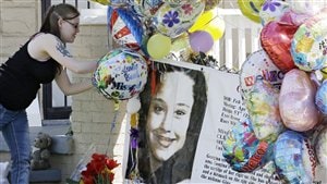Una mujer agrega un globo festivo frente a la casa de Gina DeJesus una de las desaparecidas de Cleveland que regresó a casa.