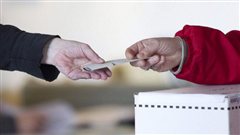 Un bulletin de vote devant une urne �lectorale