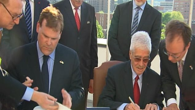Signature du document qui permet à l'OACI de demeurer à Montréal. À la gauche on aperçoit le ministre canadien Affaires étrangères, John Baird.