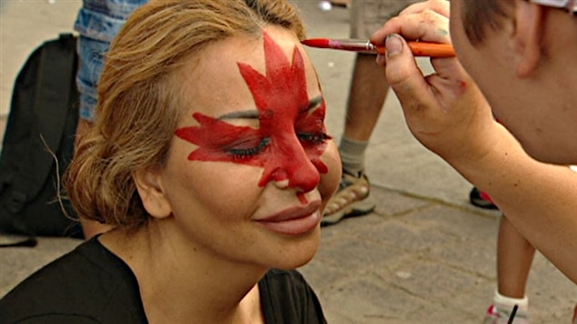 Une jeune fille se fait maquiller une feuille d'érable sur le visage lors de la fête du Canada à Ottawa.