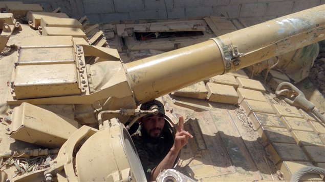 صورة نشرت اليوم لمقاتل من المعارضة يرفع شارة النصر من داخل دبابة في محيط مدينة حماة في وسط غرب سوريا