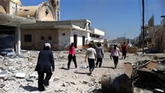 Des syriens marchent dans les ruines � Qousseir le 6 juin, apr�s la prise de la ville par l'arm�e syrienne.