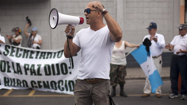 Un hombre que apoya al ex dictador Rios Montt levanta su puño durante una manifestación frente a la cárcel.
