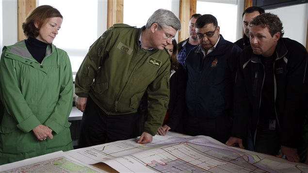 La premier ministre albertaine, Alison Redford, et le premier ministre canadien, Stephen Harper, regardent les cartes des secteurs inondés de Calgary.