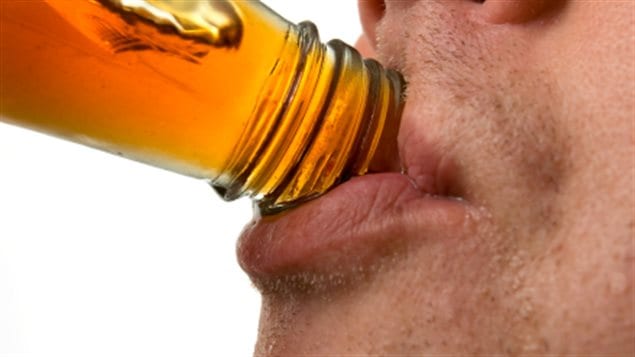 Un homme boit une bouteille d'alcool 