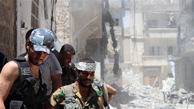 مقاتلون من المعارضة السورية بعد تفجيرهم مبنى في حي صلاح الدين في حلب مستهدفين قناصاً تابعاً للنظام كان مختبئاً بداخله لكنه نجح في الهرب