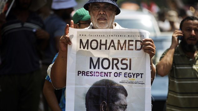 أحد مناصري الرئيس المصري المعزول محمد مرسي رافعاً صورته أمس في القاهرة
