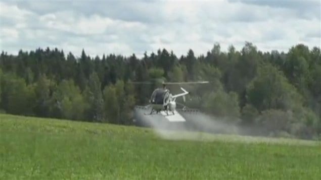 Un hélicoptère répand des pesticides sur un champ