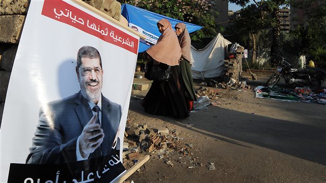 مواطنون مصريون قرب صورة للرئيس المعزول محمد مرسي