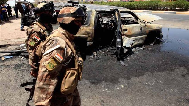رجال شرطة عراقيون في موقع انفجار سيارة  مفخخة في البصرة