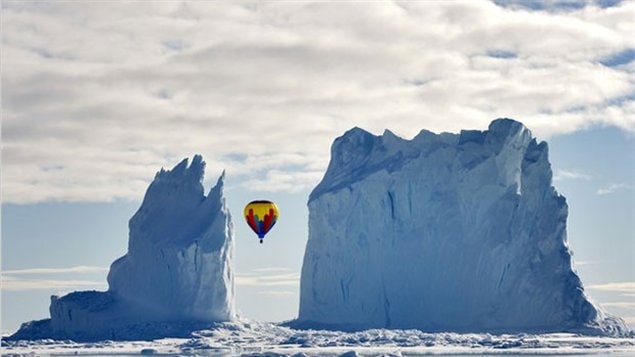 A colourful hot-air balloon flying between two icebergs near Arctic Bay, Nunavut.
