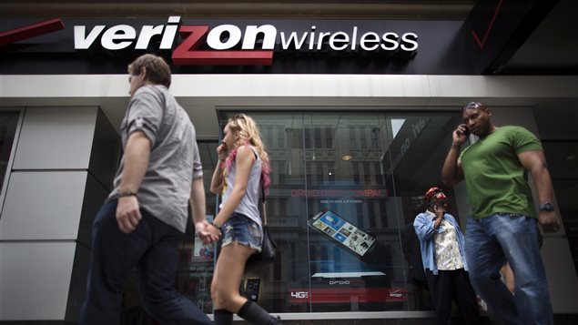 Des piétons passent devant une boutique Verizon à New York, le 6 juin 2013