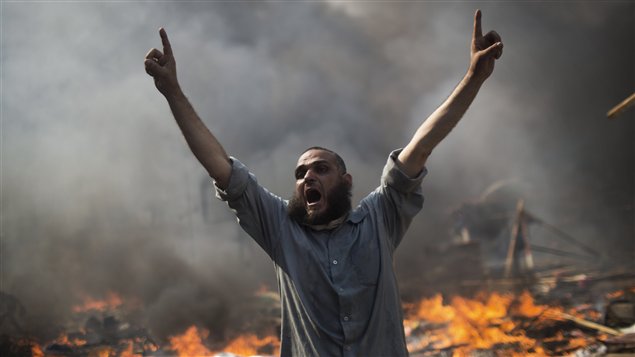 أحد مناصري الرئيس المصري المعزول محمد مرسي يصرخ ملء رئتيه خلال الاشتباكات مع قوات الأمن أمس في محيط مسجد رابعة العدوية في مدينة نصر في القاهرة 