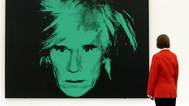 Une femme contemple le tableau <em>Self-portrait</em> (1986) d'Andy Warhol lors d'une exposition de ses oeuvres en Allemagne. | ©AFP/Volker Hartmann Une femme contemple le tableau <em>Self-portrait</em> (1986) d'Andy Warhol lors d'une exposition de ses oeuvres en Allemagne. | ©AFP/Volker Hartmann