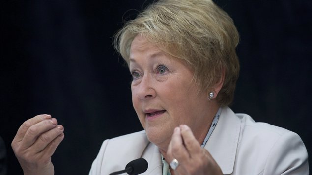 Premier Pauline Marois is counting on the support of French-speaking Quebecers to create the new Charter of Quebec Values. She is show in shown in a light powder blue suit behind a mike and gesturing with both hands.