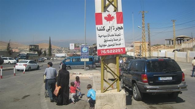 لافتة تدعو السوريين للجوء إلى كندا على الحدود اللبنانية السورية