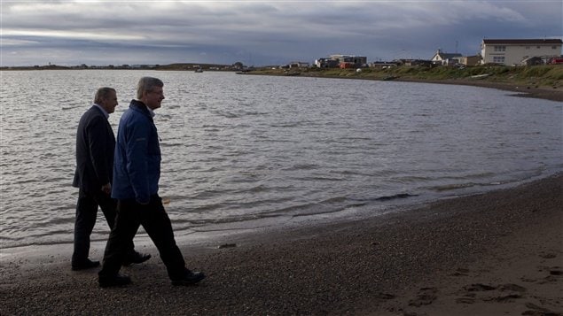 Prime Minister Stephen Harper, right, walks on the shore of the Beaufort Sea in 2010 with then . 