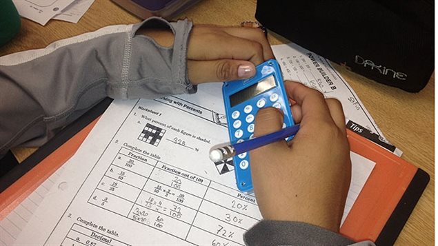 Un élève tient une machine à calculer.