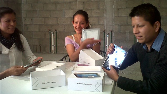 Tres estudiantes que fueron responsables de enseñar las nuevas tecnologías a sus familias, reciben tabletas en San Miguel de Allende, México.