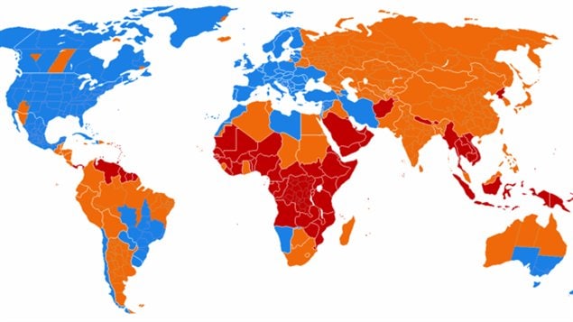 Carte du monde montrant l’utilisation actuelle et passée de l’heure d’été. En bleu : régions utilisant l’heure d’été. En orange : régions qui n’utilisent plus l’heure d’été. En rouge : régions n’ayant jamais utilisé l’heure d’été.