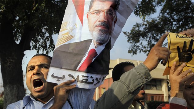 Un partisan de Mohamed Morsi brandit une affiche du président déchu.