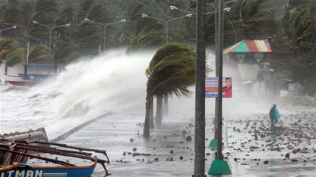 Un ciudadano camina junto a las inmensas olas causadas por el tifón.