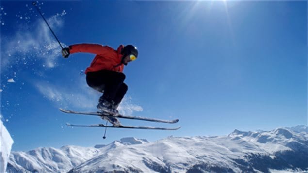 Un skieur fait un saut sur une piste en montagne